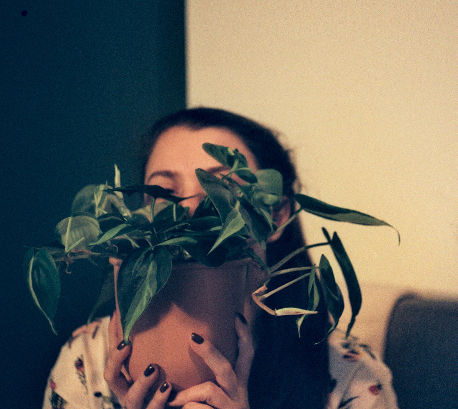 My wife holding a plant infront of her face