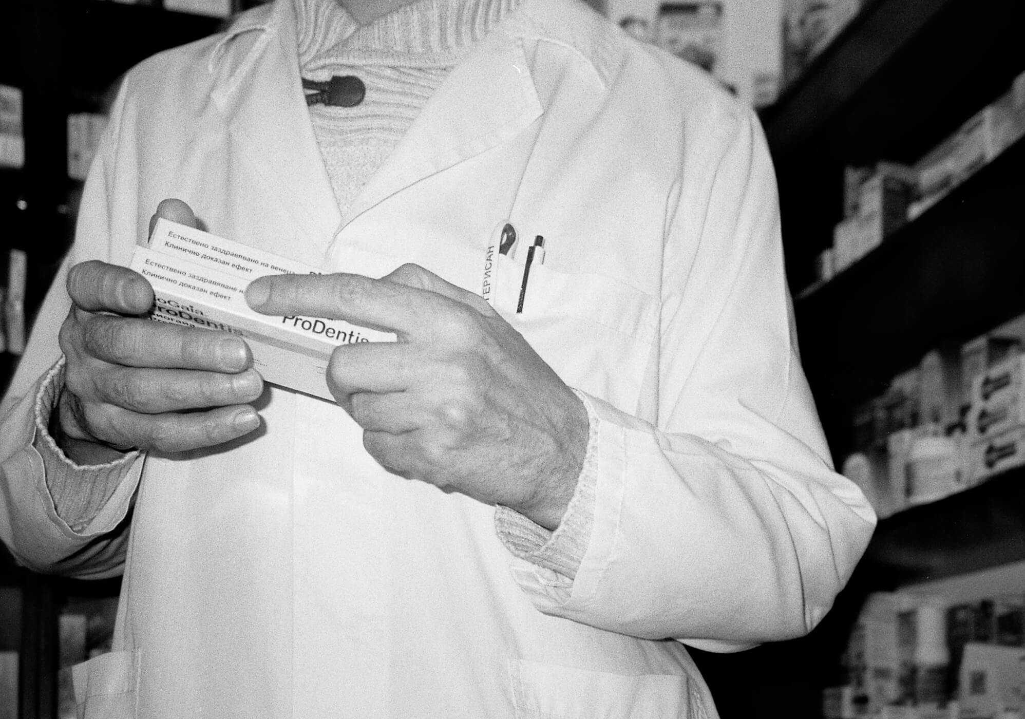 Black and white photo of the hands of my father holding medicine in his pharmacy